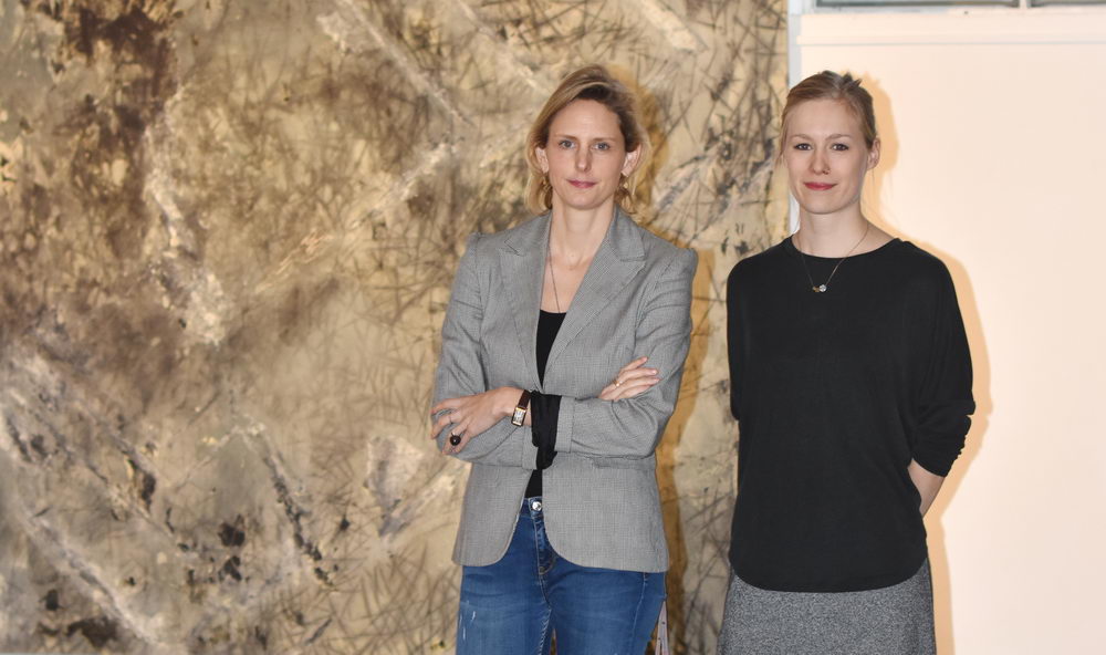 Katharina Schlüter und Julia Kölle von der Sparkassen Kulturstiftung vor einem der ausgestellten Werke im Marstall.  Foto: SL 